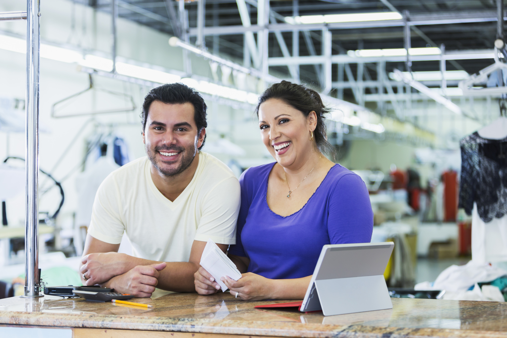 Two laundromat owners stand at front desk