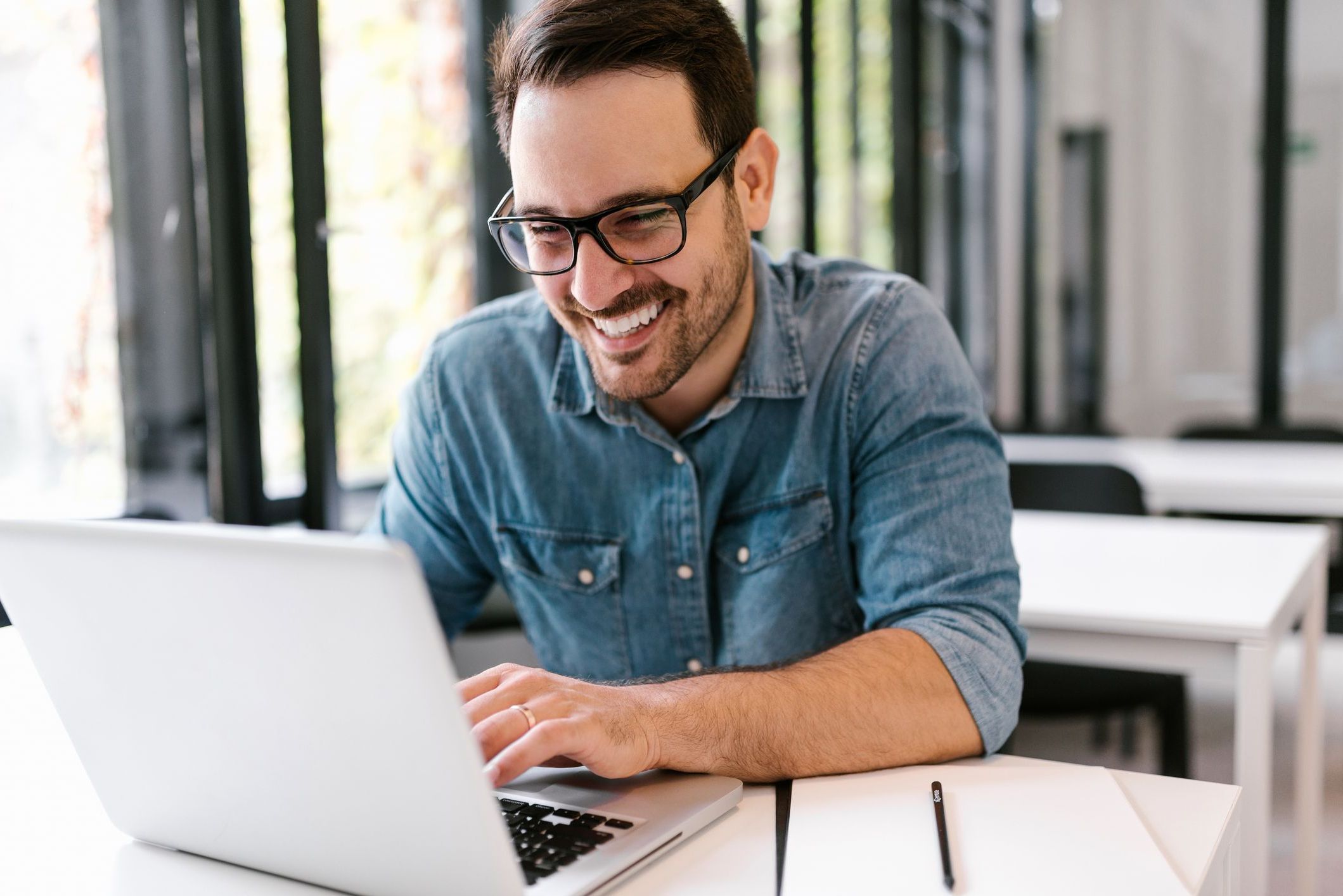 Happy young man using laptop. Close-up.