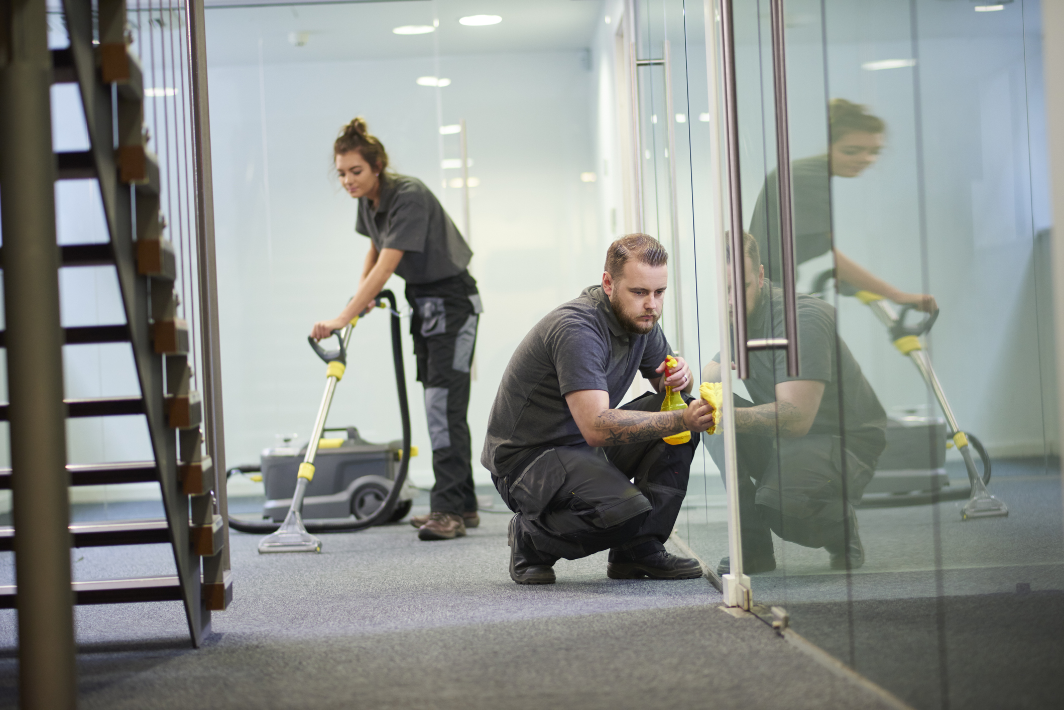 Two workers clean an office
