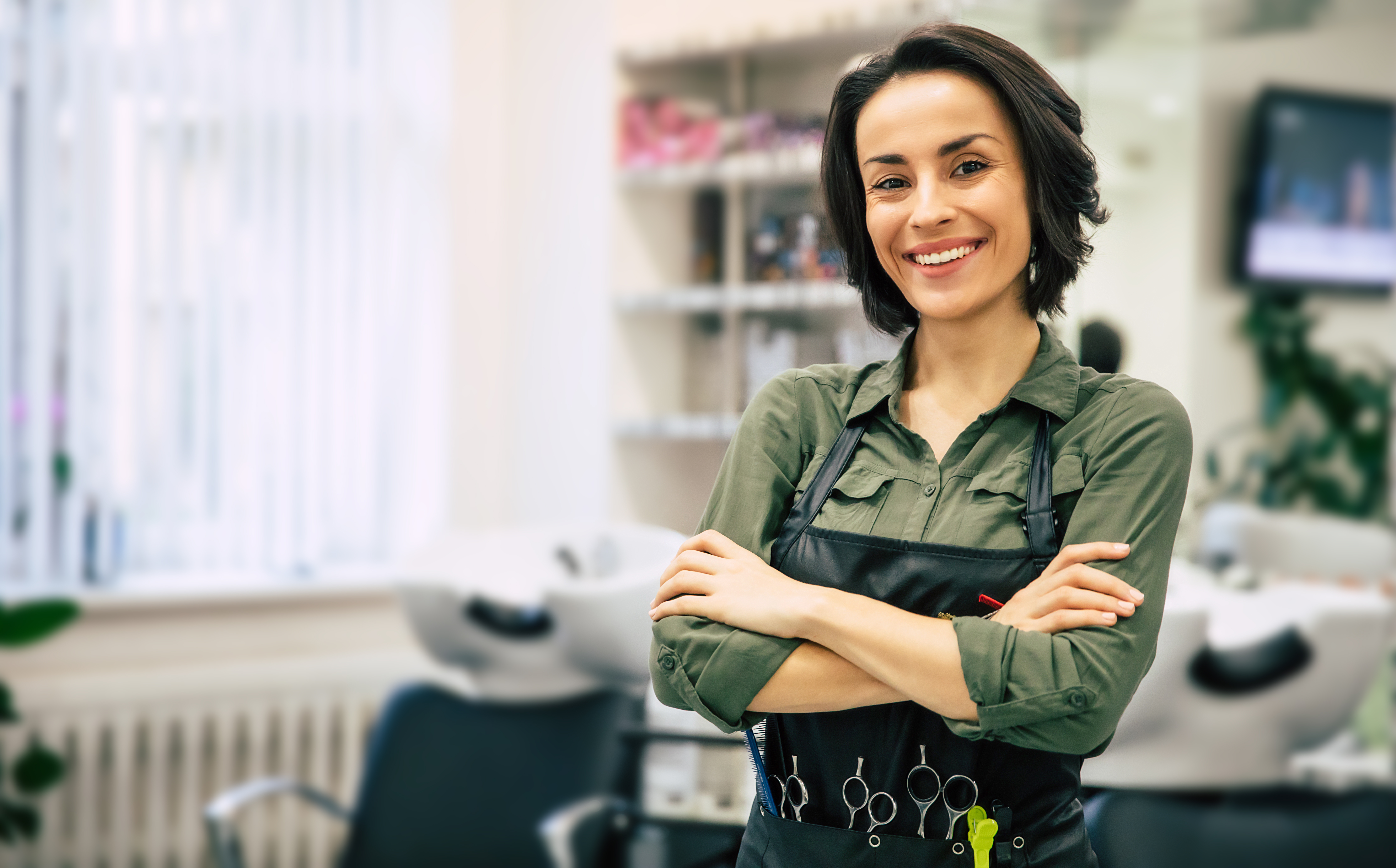 Woman hairstylist with cosmetology insurance looking at camera