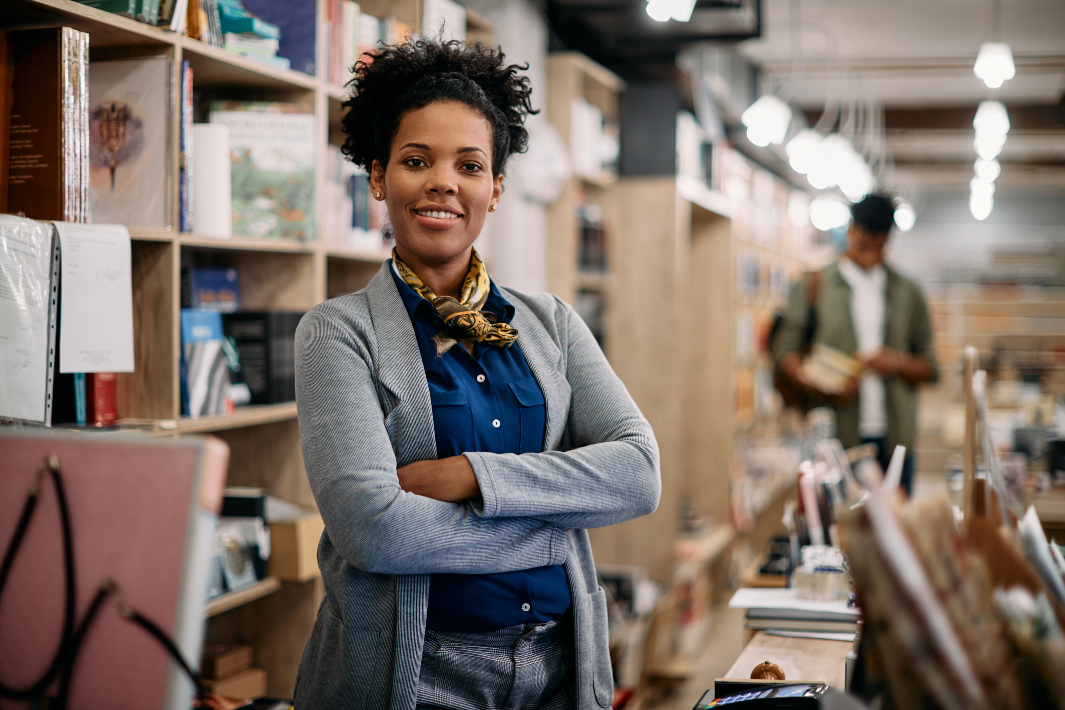 Woman poses in front of bookshelf