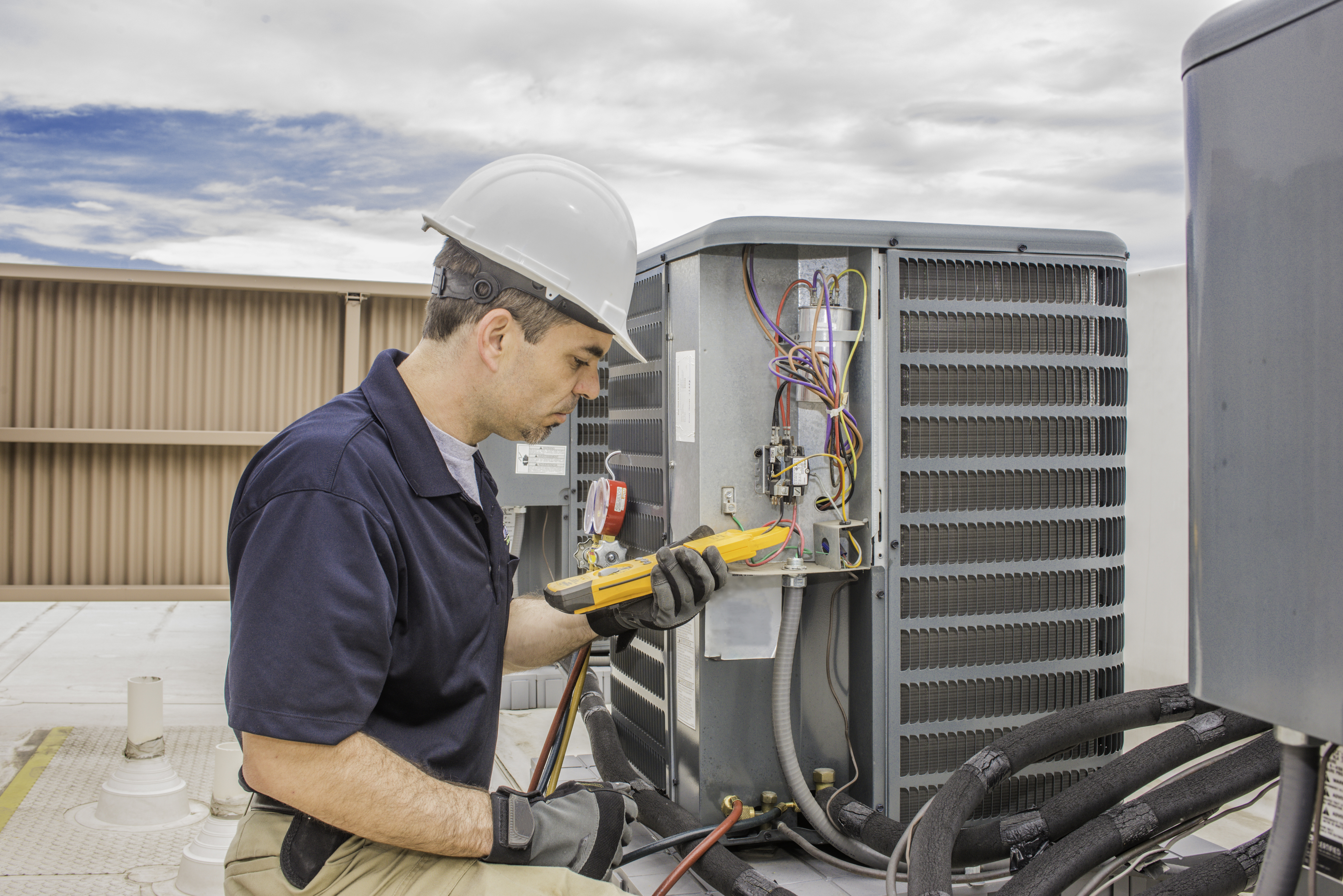 HVAC tech working on a condensing unit 